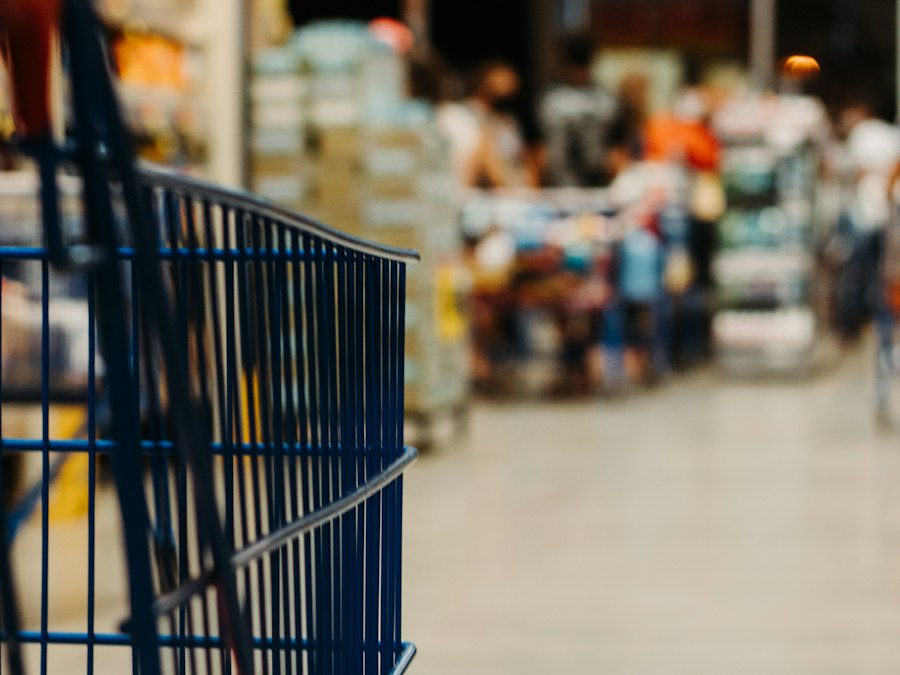 Empty shopping cart in a busy supermarket aisle