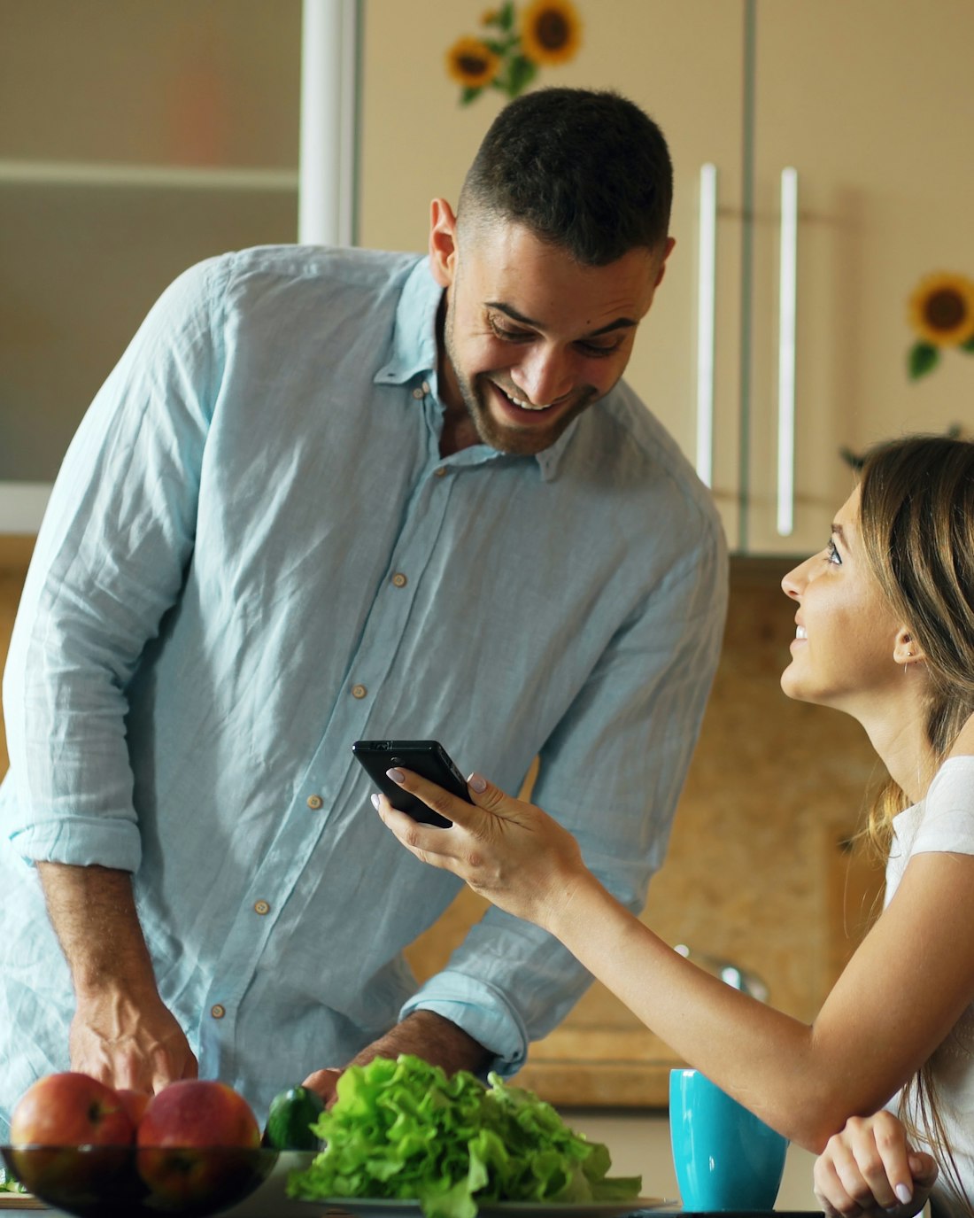 Couple choosing a recipe on a phone in their kitchen